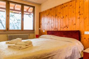 a bedroom with a bed with towels on it at Holiday Mantovani in Brenzone sul Garda