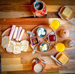 a table with plates of breakfast food and cups of coffee at Hostería Los Morteros in Purmamarca