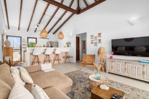 ein Wohnzimmer mit Sofa und Fernseher in der Unterkunft Kas Palma at Waterland's Village - Private pool! in Kralendijk