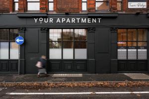 une personne marchant devant un bâtiment dans l'établissement Tower Bridge Road I Your Apartment, à Londres