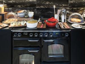a kitchen with an oven with food on top of it at Mercure Nancy Centre Place Stanislas in Nancy