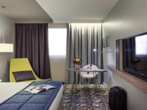 Habitación de hotel con cama, mesa y TV. en Mercure Paris Val de Fontenay, en Fontenay-sous-Bois