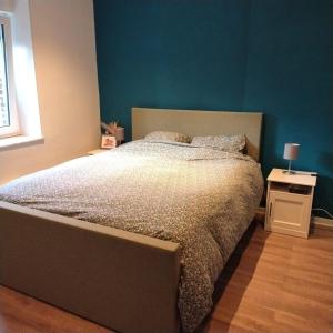 a bedroom with a bed and a blue wall at Grande maison familiale à Theux in Theux +15 photos