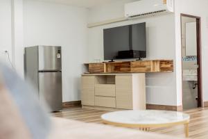 un salon avec une télévision à écran plat et une table dans l'établissement Ao Nang Boutique Apartment & Pool, à Ban Chong Phli