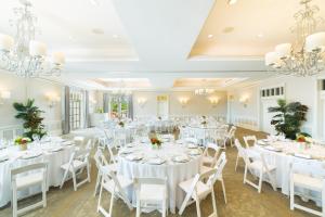 una stanza con tavoli e sedie bianchi e lampadari a braccio di The Palms Turks and Caicos a Grace Bay Altre 41 foto