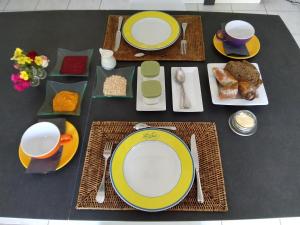 a table with yellow and white plates and food on it at Chez Caroline Chambre d'Hôtes in Plouër-sur-Rance
