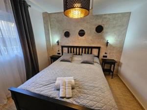 a bedroom with a bed with two towels on it at Piso Romántico con piscina in Formentera de Segura