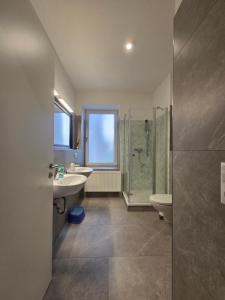 a bathroom with two sinks a toilet and a shower at Apartment am Saaleradwanderweg in Merseburg