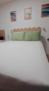 a bed with two green pillows on top of it at MA Prime Stay in Natal