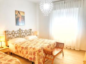 Un dormitorio con una cama y una lámpara de araña. en Tina Piano Terra, en Castiglione della Pescaia