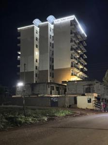 a tall building with lights on top of it at night at Bliss Stay Ruaka in Ruaka