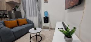 a living room with a blue couch and a table at Bliss Stay Ruaka in Ruaka