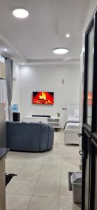 a living room with a blue couch and a painting on the wall at Bliss Stay Ruaka in Ruaka +4 photos