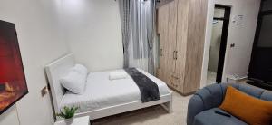 a small bedroom with a bed and a chair at Bliss Stay Ruaka in Ruaka