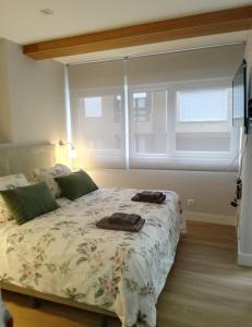 a bedroom with a large bed with a floral bedspread at Alojamiento con encanto in Santoña