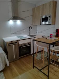 a kitchen with a table and a sink and a microwave at Alojamiento con encanto in Santoña