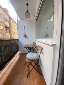 a small balcony with a chair and a table at Alojamiento con encanto in Santoña