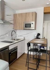 a kitchen with a table and a microwave at Alojamiento con encanto in Santoña