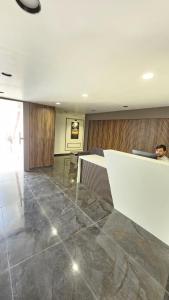 a lobby with a marble floor and a reception desk at Hotel Shyam Inn in Vadodara