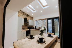 a kitchen with a wooden table with flowers on it at Marine Cottage 1 - With Private Hot Tub in Newbiggin-by-the-Sea