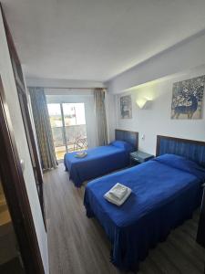 a hotel room with two beds and a balcony at Le Mirage Ibiza in San Antonio