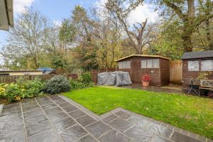 a backyard with a garden and a shed at Pass the Keys Modern 3Bed Garden Parking Nr Hainault Station in Chigwell