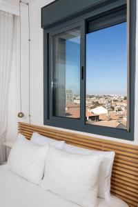 JLM market suite في القدس: غرفة نوم مع نافذة وسرير مع وسائد بيضاء