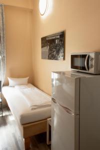 een kleine kamer met een bed en een magnetron bij Pension 11 Apartments by Lorenc in Berlijn