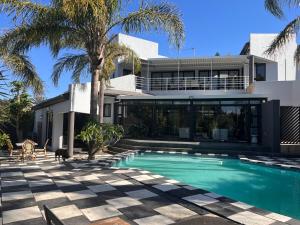 a house with a swimming pool in front of a house at 2 on Aurora Island in Durbanville