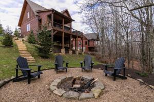 a group of chairs around a fire pit in front of a house at Overlook Nook at Eagles Nest in Elk Park