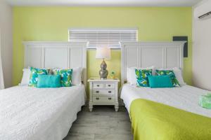 zwei nebeneinander stehende Betten in einem Schlafzimmer in der Unterkunft The Banana Bird at Cottages in Sand Bluff