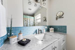 ein Badezimmer mit Waschbecken und Spiegel in der Unterkunft The Banana Bird at Cottages in Sand Bluff + 41 Fotos