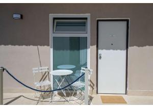 a patio with a chair and a table and a door at Maison Vittoria in Ischia Town