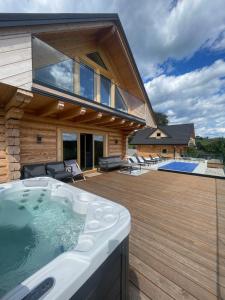 a house with a hot tub on a wooden deck at Skalna Osada in Istebna