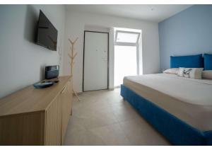 a bedroom with a bed and a desk with a television at Maison Vittoria in Ischia Town