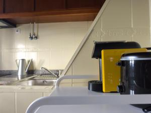 a kitchen with a yellow coffee maker on a counter at Casa do Adro in Torre de Moncorvo