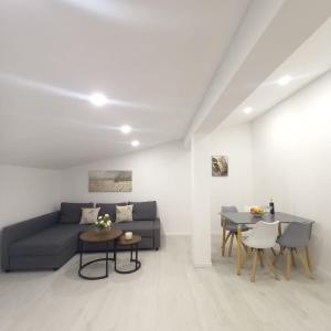 a living room with a blue couch and tables at Apartman Tony in Međugorje