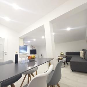 a white living room with a table and chairs at Apartman Tony in Međugorje