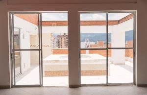 an open glass door with a view of a building at Apartamento Central Parque de Sabaneta-901 in Sabaneta