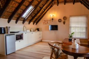 a kitchen with white cabinets and a wooden table at Ikhaya Safari Lodge in Cape Town