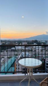 a table on a balcony with a view of a city at New great pool and gym condo chiangmai in Chiang Mai