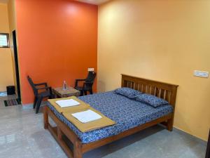 マルバンにあるHotel Vedanshのベッドとテーブルと椅子のある寝室