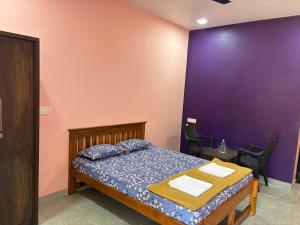 マルバンにあるHotel Vedanshの紫の壁のベッドルーム1室(ベッド1台付) +4枚の写真