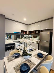 a kitchen with a table with blue plates and glasses at New great pool and gym condo chiangmai in Chiang Mai