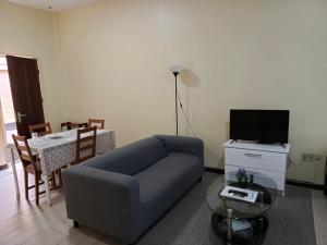 パラマリボにあるWilhelmina Hotel & Apartmentsのソファとテーブルのあるリビングルーム