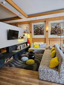 una sala de estar con un sofá y un televisor en Hôtel et appart'hôtel de l'Hermitage, en Thônes