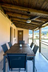 een houten tafel met stoelen en een plafondventilator bij Villa Natura in Kavala