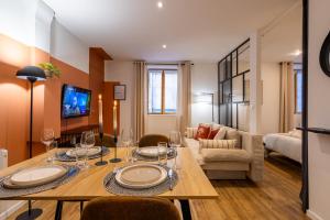 un salon avec une table, des chaises et un canapé dans l'établissement L'Occitane - Grand Studio Chaleureux en Hyper centre, à Castres