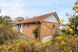 une petite maison en briques au milieu d'un champ dans l'établissement Schwanenuferhaus, à Hestoft