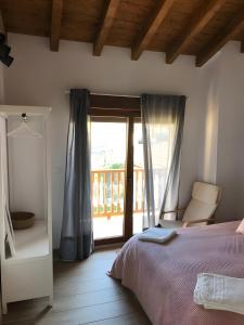 a bedroom with a bed and a window with a balcony at El Rincón De Cabello in Sierra